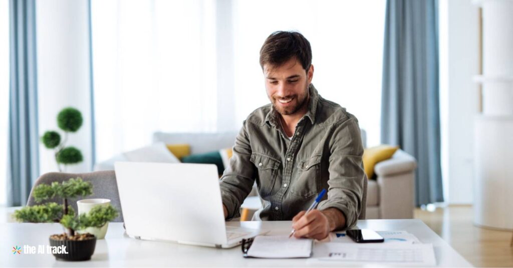 Free Online AI Courses - A man sitting at a desk writing on a book - Image Credit Canva